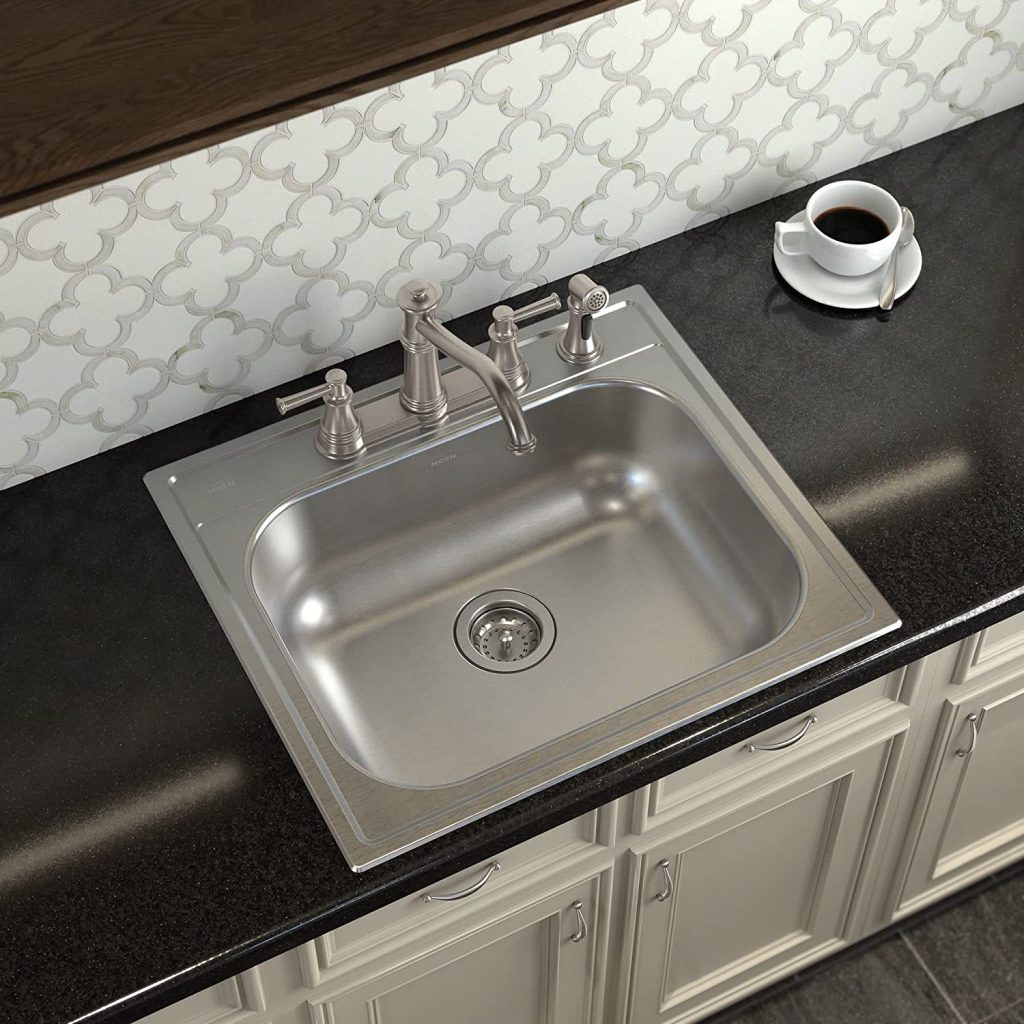 A single bowl stainless steel sink with topmount installation, featuring a classic drop-in edge on a dark countertop