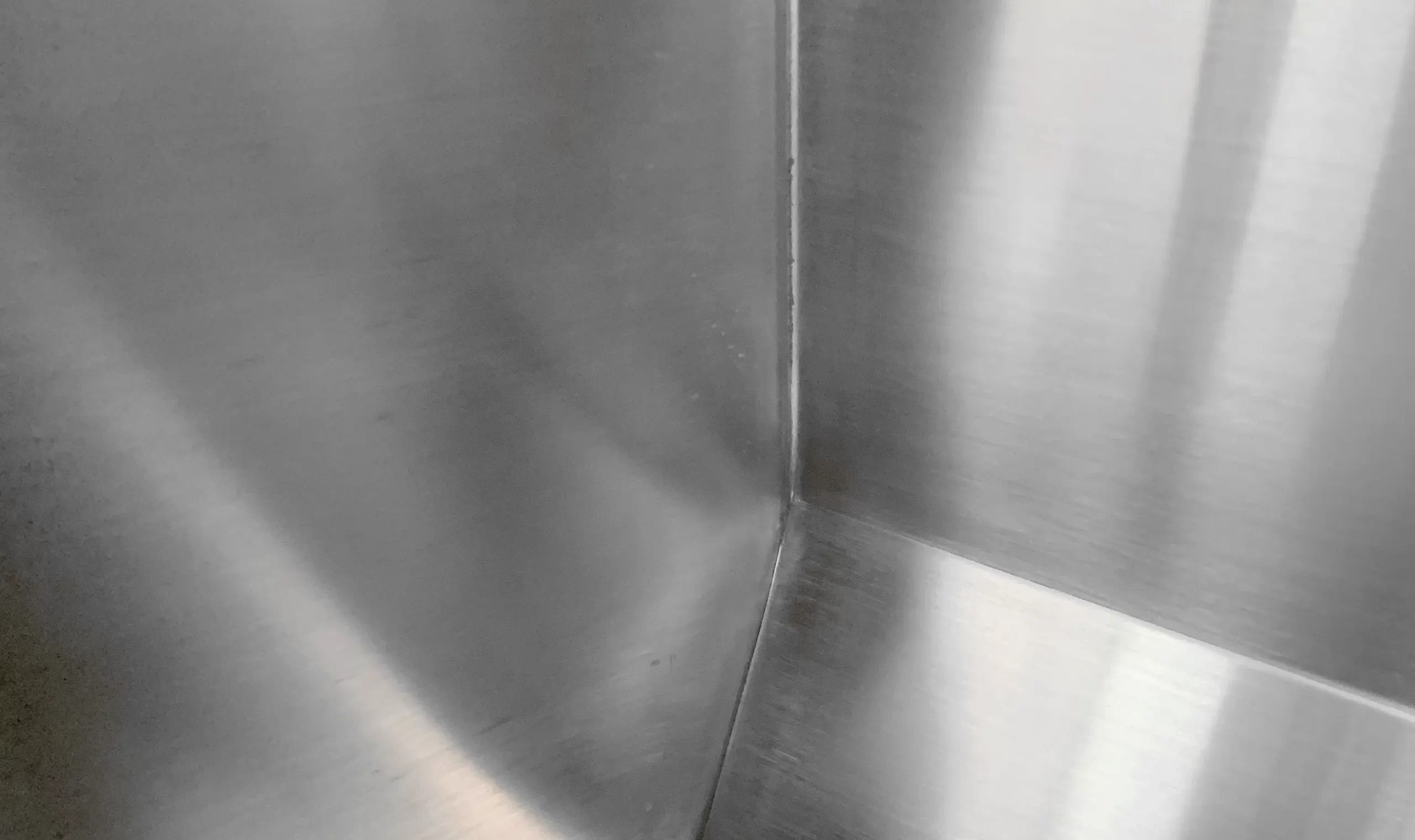 Seamless one-piece construction of a stainless steel wudu wash basin showing the welded stool and deep foot sink