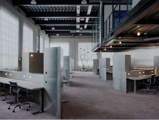Bespoke metalwork and custom stainless steel fabrication creating open-plan workspace dividers in a design studio