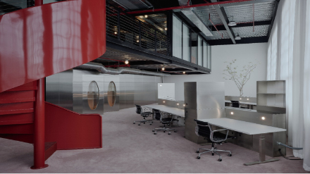 Architectural metal crafting and custom stainless steel fabrication for workstation desks near a red spiral staircase